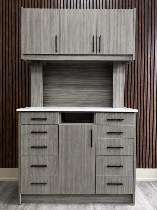 Light grey woodgrain 12 o'clock rear dental cabinet by DRM Dental with upper cabinets, quartz countertop, and ten drawers
